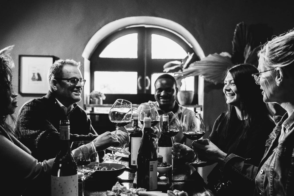 Harry Hartman black and white image friends drinking wine, cheers